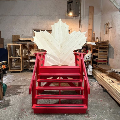 Red staircase with a large white leaf-like structure in a workshop setting