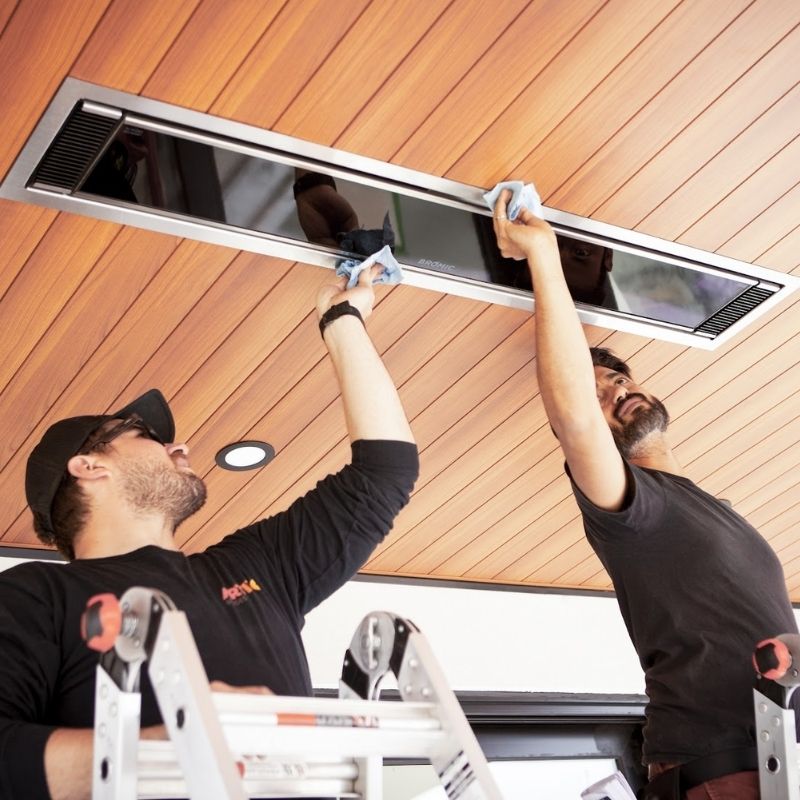 Two guys cleaning the readiant heater