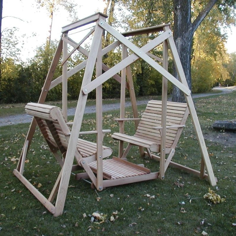 Classic graden swing set with two chairs on a grassy area with trees in the background