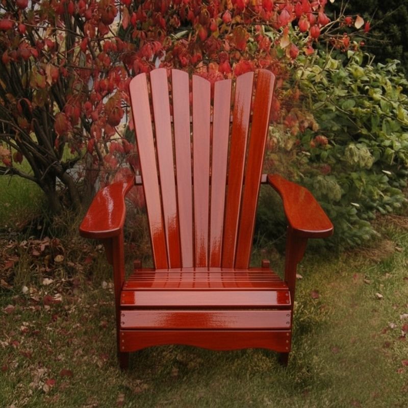 Wooden Adirondack chair on a patio with greenery in the background - wave back  mahogamy glossy - clear cedar