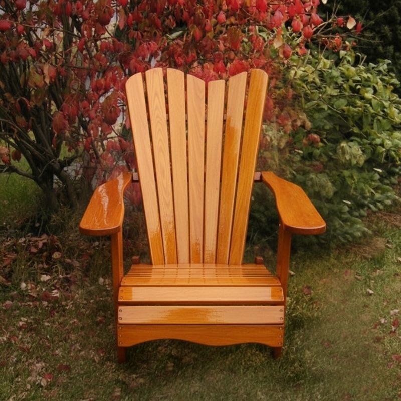 Wooden Adirondack chair on a patio with greenery in the background - wave back  golden glossy - clear cedar