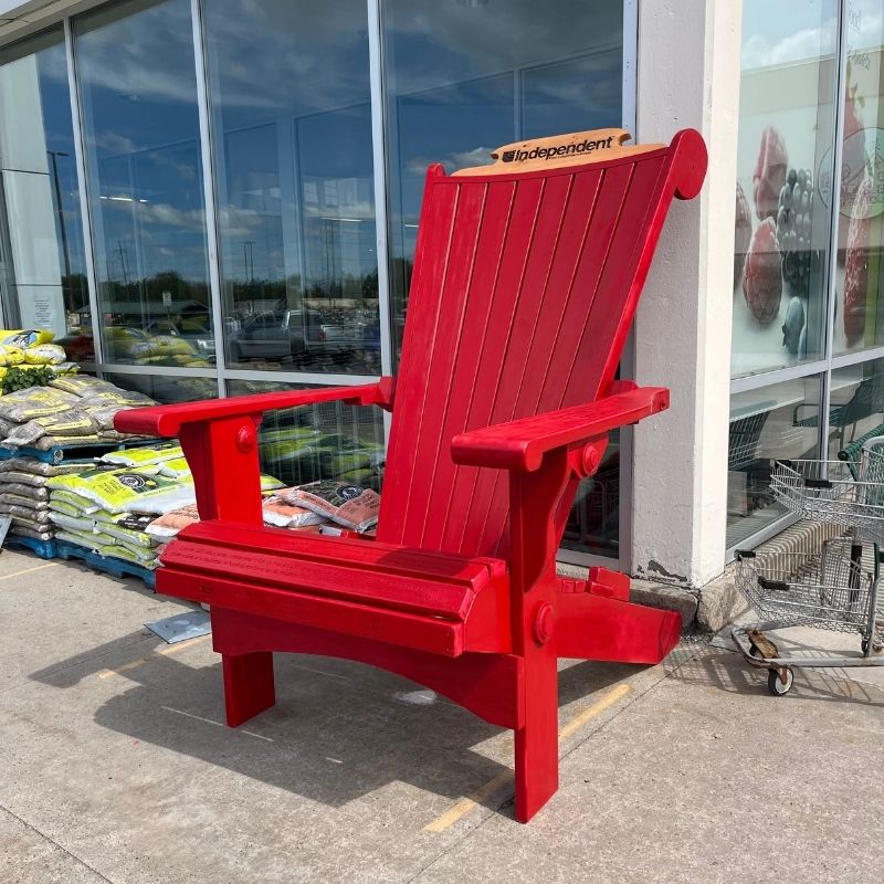 Red Customized Giant with a shopping cart on top, outside a store.