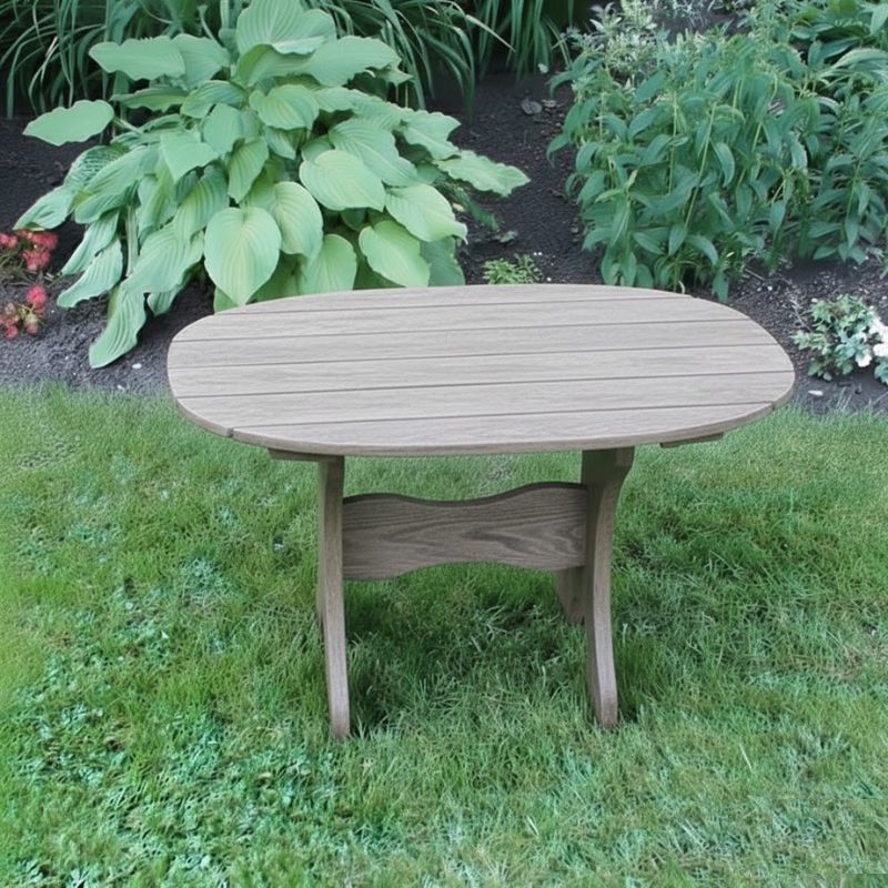 Oval Side Table in a grassy area with plants in the background - poly luxe - woodgrain driftwood grey