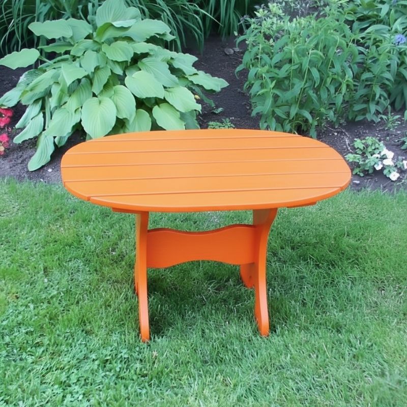 Oval Side Table in a grassy area with plants in the background - poly luxe - orange