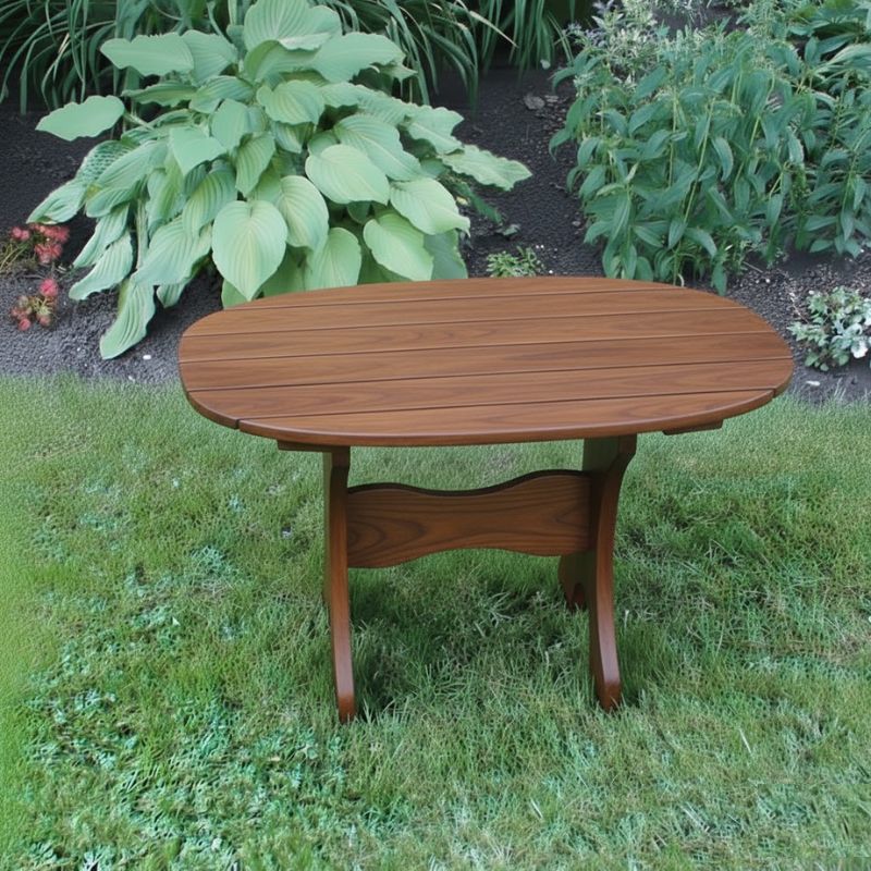 Oval Side Table in a grassy area with plants in the background - poly luxe - woodgrain brazilian walnut