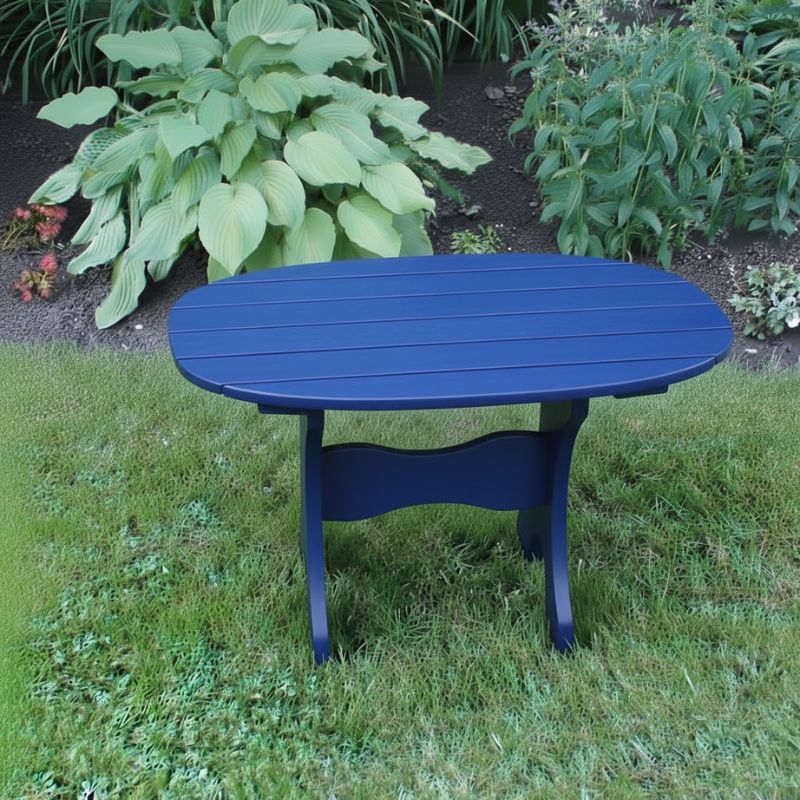 Oval Side Table in a grassy area with plants in the background - poly luxe - blue