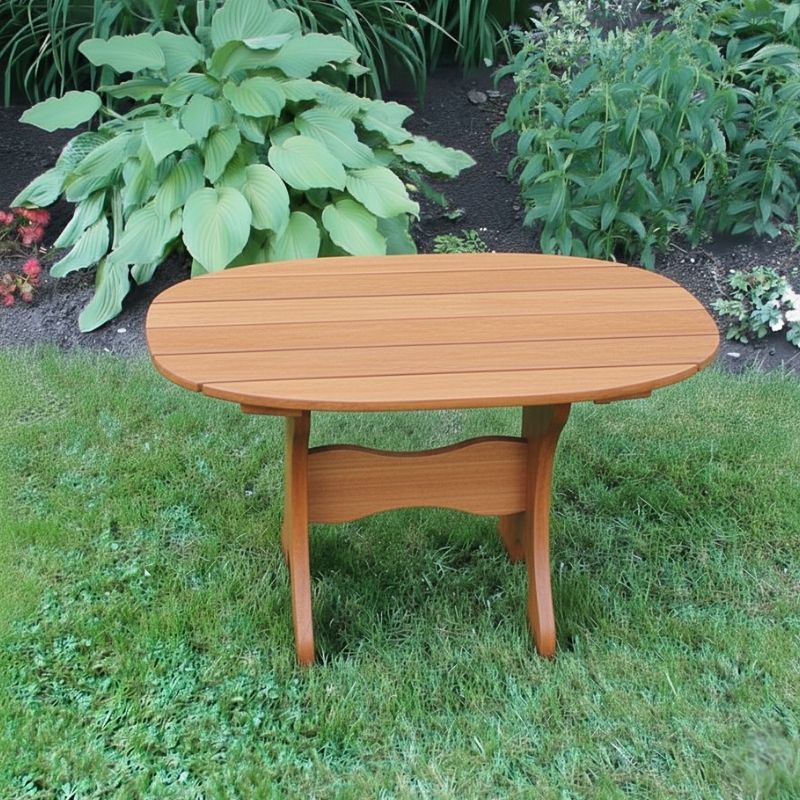 Oval Side Table in a grassy area with plants in the background - poly luxe - cedar