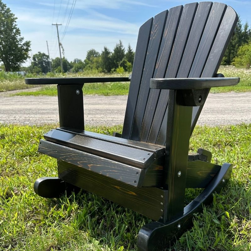 Royal Rocking Adirondack Chair (Large) on grass with a road and trees in the background