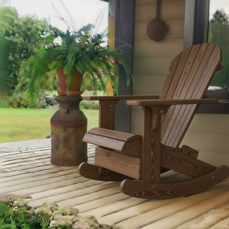Royal Rocking Adirondack Chair (Large) on a porch with a potted plant and garden view - poly luxe - woodgrain brazilian walnut