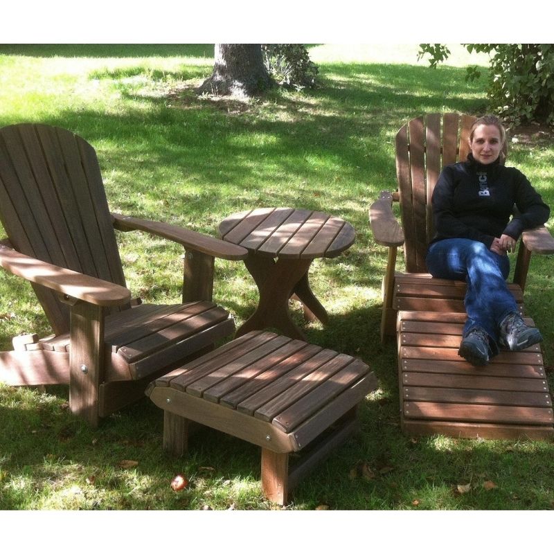 Person sitting on a wooden Adirondack chair in a grassy outdoor setting