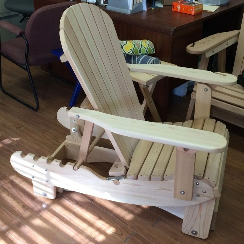 Unstained Royal Reclining Glider on a wooden floor with a blurred background