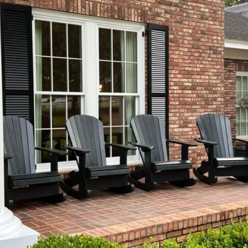 Four Royal Rocking Adirondack Chair (Large) on a brick patio in front of a brick house.