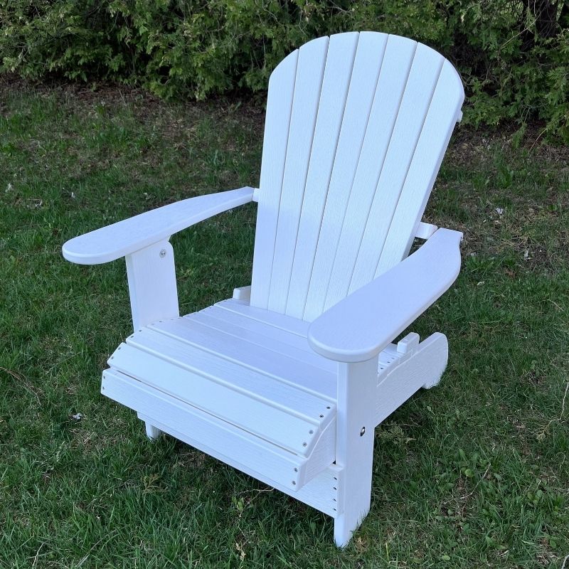 White Royal Upright Adirondack Chair, on grass with greenery in the background