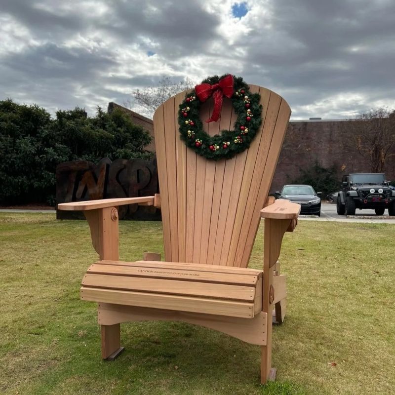 Traditional Giant chair with a Christmas wreath on a grassy area.