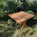 24" Square Side Table in a natural outdoor setting with greenery - clear cedar - golden glossy in a natural setting with greenery - poly luxe - cedar