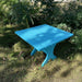 24" Square Side Table in a natural outdoor setting with greenery - clear cedar - golden glossy in a natural setting with greenery - poly luxe - aruba blue
