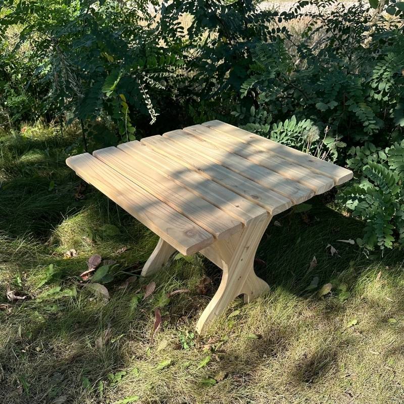 Wooden table in a natural outdoor setting with greenery