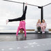 Two girls sitting on the Acon X Inflatable Triangle Block. The girl stands with her hands on the trampoline.