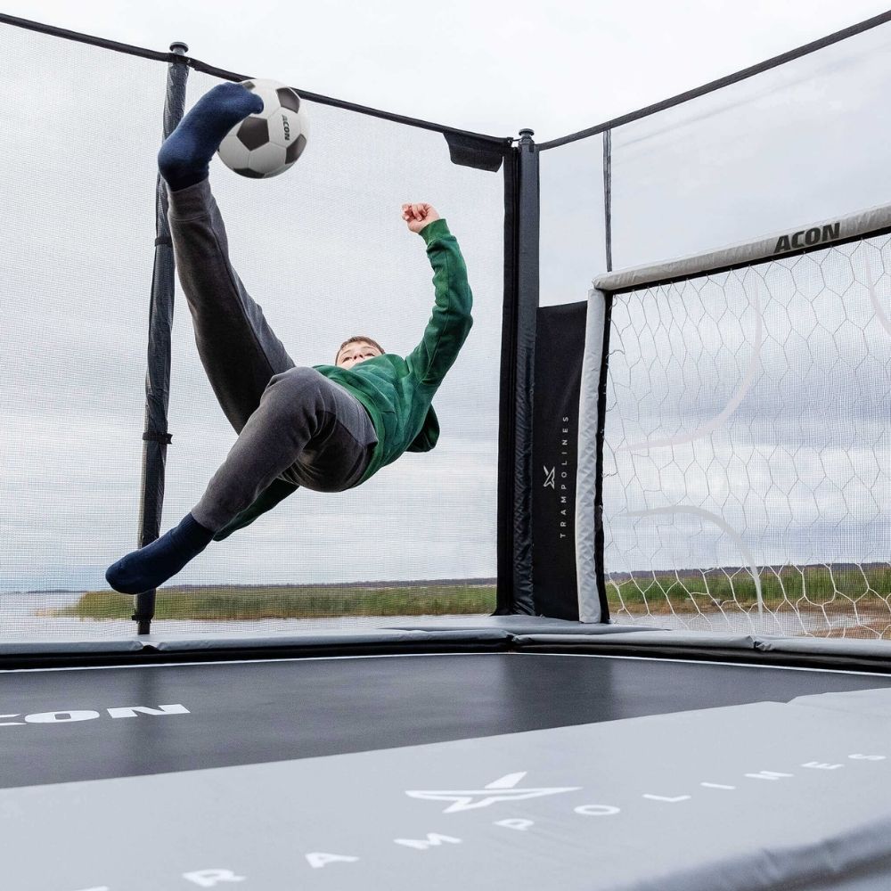 Two boys playing soccer on Acon X 17 Trampoline with soccer panel