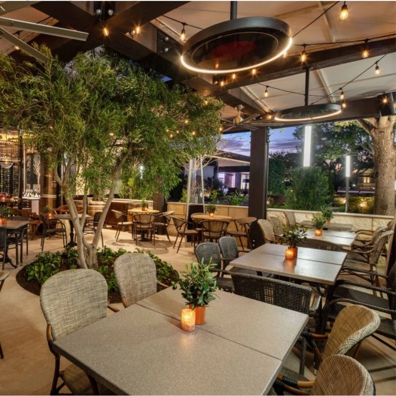 Outdoor dining area with tables, chairs, and decorative elements in a restaurant setting.