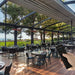 Indoor dining area with outdoor view, person holding a remote control