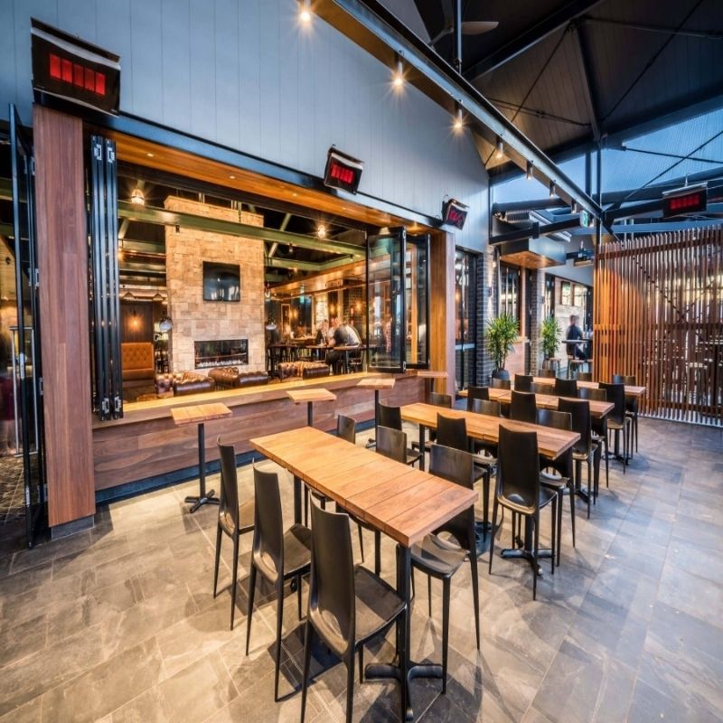 Bromic Platinum/Tungsten Gas Mounting Bracket - Installed in modern restaurant interior with wooden tables and chairs, large windows, and a bar area.
