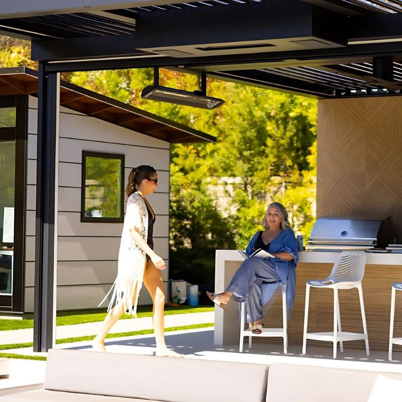 Two women in an outdoor setting, with heaters intsalled using mounting poles.