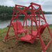 Red Classic Garden Swing set by a lake with trees in the background