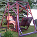 Woman with a dog sitting on a classic graden swing set in a garden.
