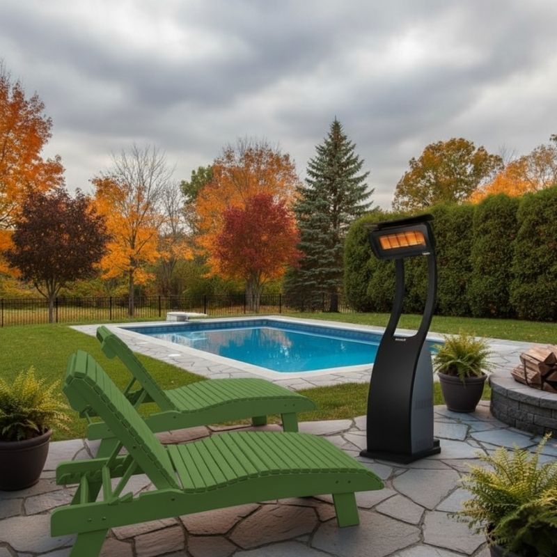 Lime green lounge chairs by a pool with an outdoor heater on a stone patio, autumn trees in the background.