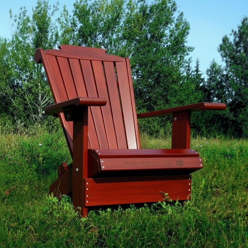 Wooden Adirondack chair on a patio with greenery in the background - mahogamy glossy - clear cedar