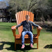 Man sitting on Customized Giant orange  chair outdoors.
