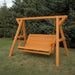 Orange Family Porch Swing with Frame set on grass with trees in the background