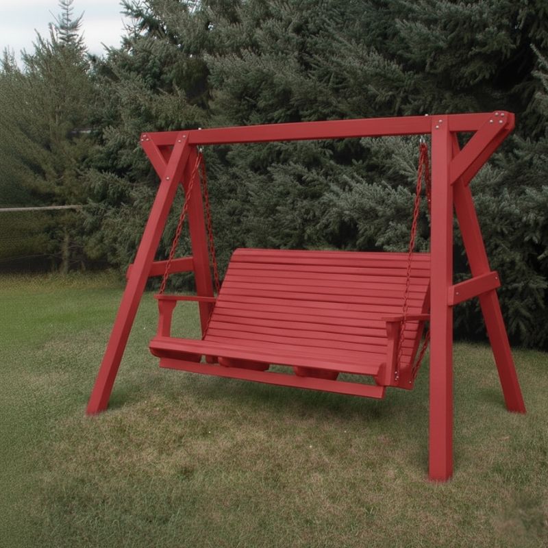 Red Family Porch Swing with Frame set on grass with trees in the background