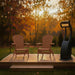 Two cedar Adirondack chairs on a wooden deck with a heater in front of autumn trees.