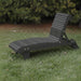 Lounge Chair on grass with trees in the background - poly luxe - dark grey