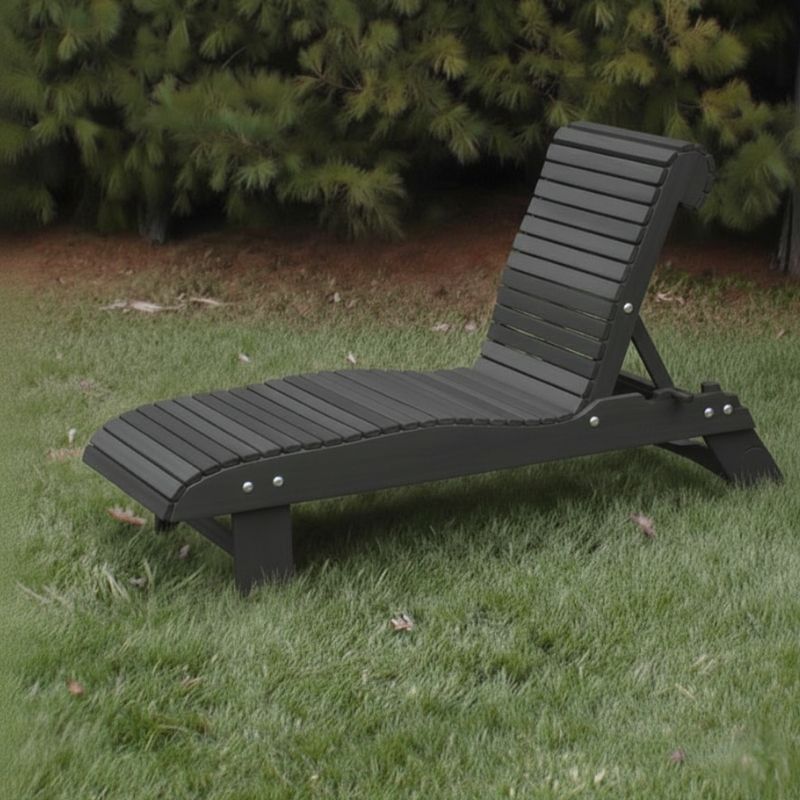 Lounge Chair on grass with trees in the background - poly luxe - dark grey