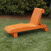 Lounge Chair on grass with trees in the background - poly luxe - orange