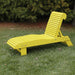 Lounge Chair on grass with trees in the background - poly luxe - lemon yellow