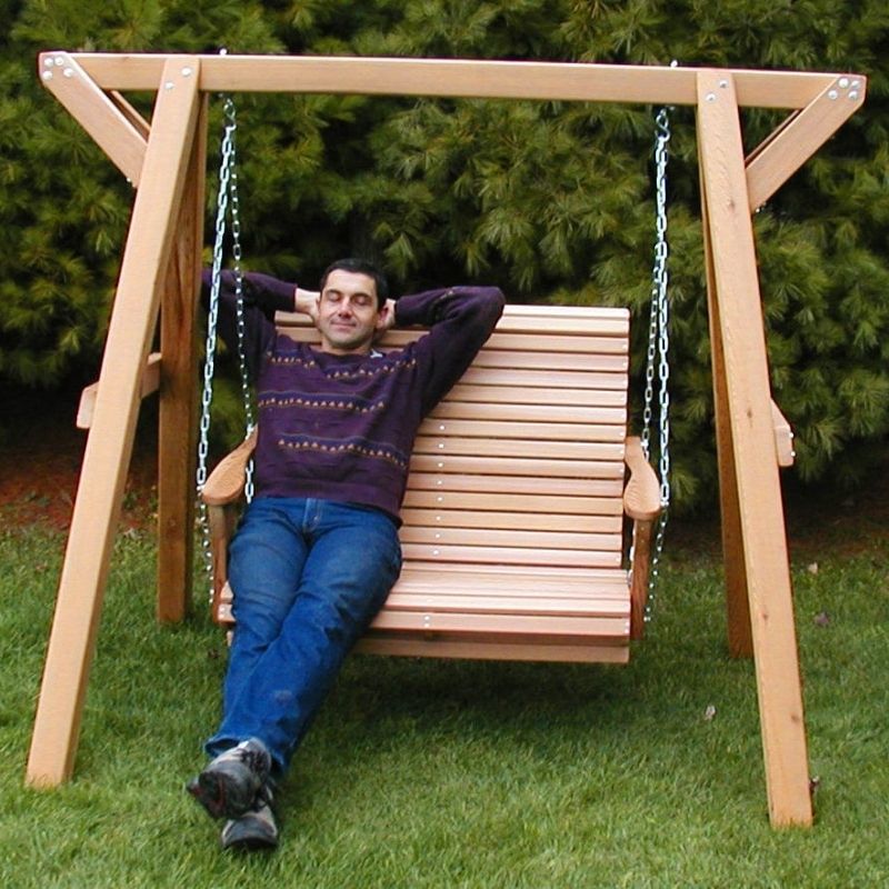 Man sitting on a wooden swing set in a garden