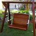Wooden swing hanging from a stand in a garden setting