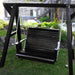 Black wooden swing on a stand in a garden setting