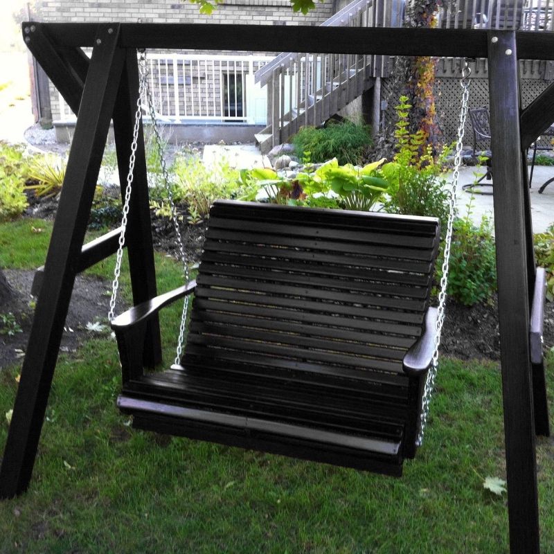 Black wooden swing on a stand in a garden setting