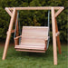 Wooden swing set with a bench seat on a grassy area with trees in the background