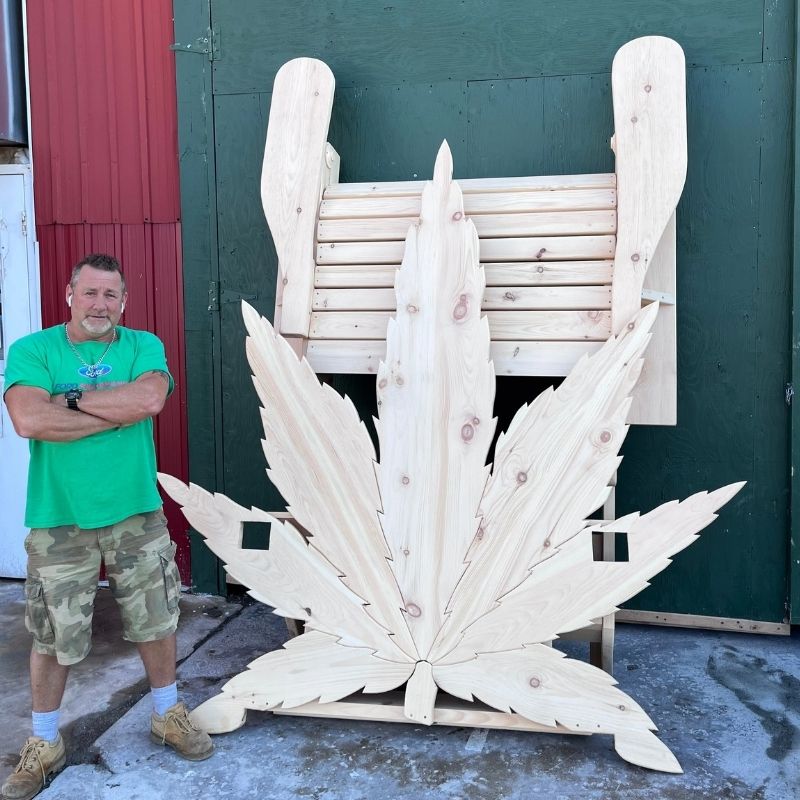 Man standing next to Marijuandack Giant in front of a green building.