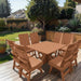 Modern Dining Set for 8 with Pedestal Table on a deck with a garden and house in the background - poly luxe - cedar