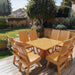 Modern Dining Set for 8 with Pedestal Table on a deck with a garden and house in the background - clear cedar - caramel glossy