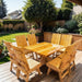 Modern Dining Set for 8 with Pedestal Table on a deck with a garden and house in the background - knotted cedar - golden glossy