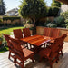 Modern Dining Set for 8 with Pedestal Table on a deck with a garden and house in the background - knotted cedar - mahogany glossy