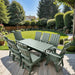 Modern Dining Set for 8 with 6' Table on a patio with a garden and house in the background - turf green